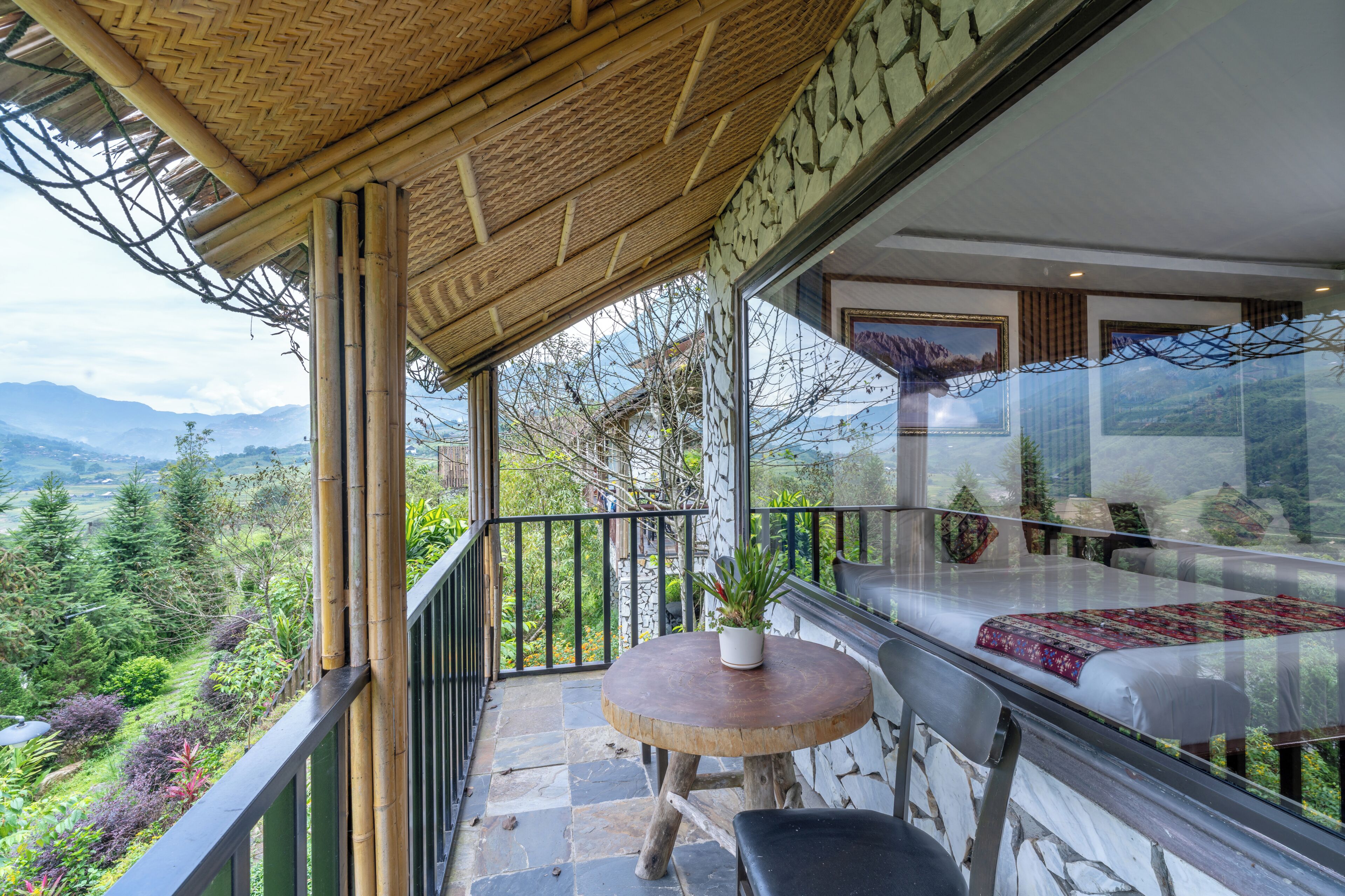 Un balcón con vistas a las montañas, una mesa y una silla.
