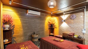 Un cuarto de spa con dos camillas de masaje, un reloj y un jarrón decorativo.
