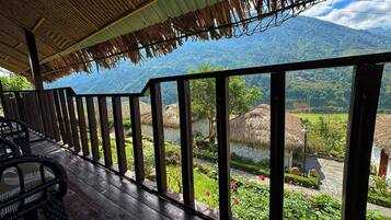 A wooden deck with a view of a mountainous landscape.