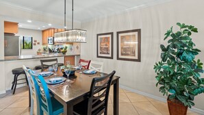 Un espace repas comprenant une table en bois, des chaises et un luminaire suspendu.