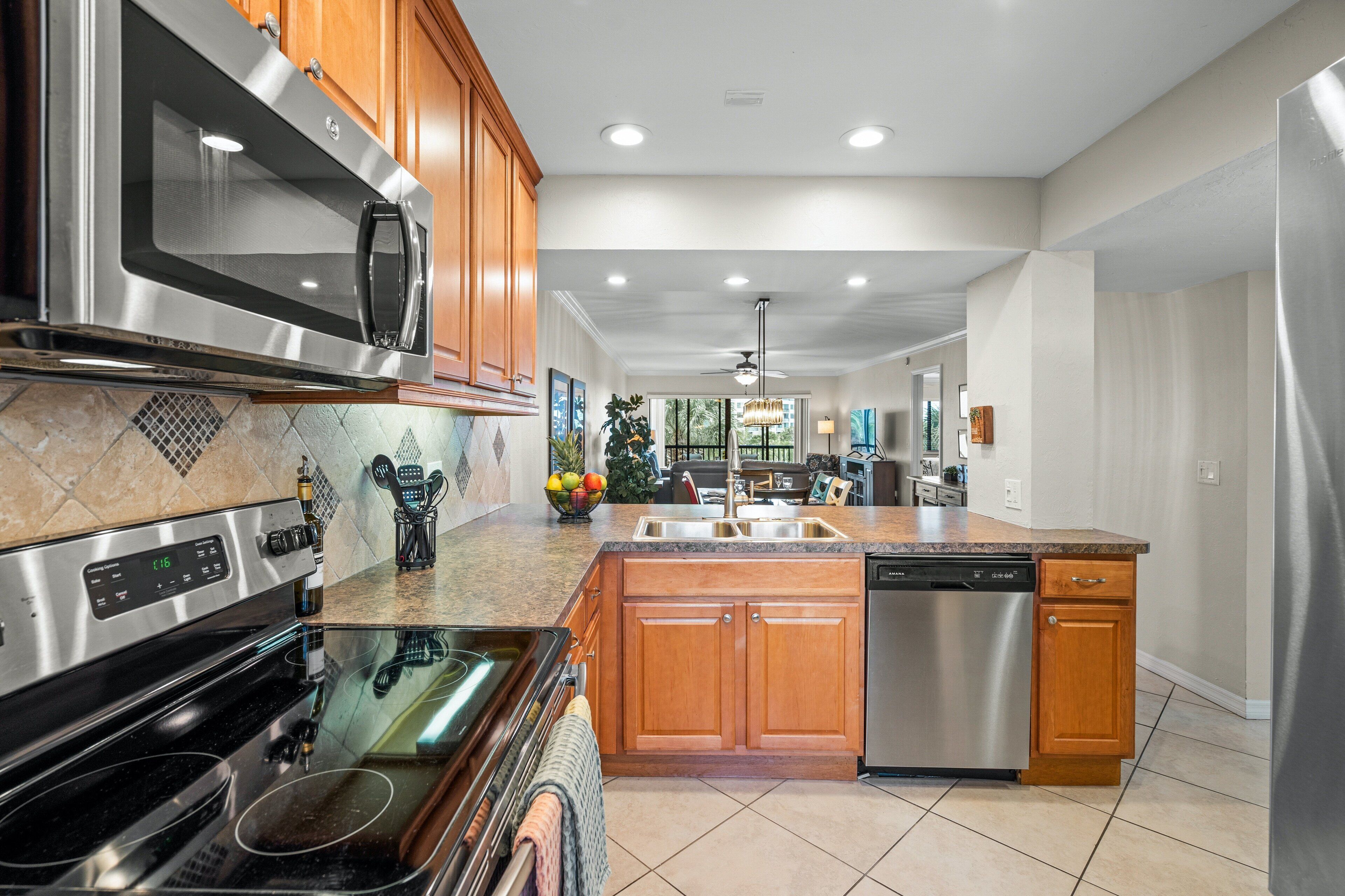 A modern kitchen with stainless steel appliances, wooden cabinets, and a central island.