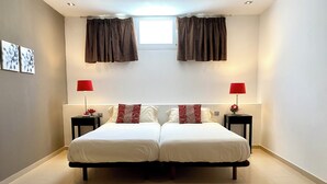 A double bed with two nightstands, each with a red lamp and a vase of flowers. - Magnificent and spacious Pearl Villa with heated pool, Wifi and AC (puerto del carmen)