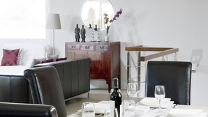 A dining area with a chandelier, a wooden table set for four, and a mirror above the table. - Modern Villa with Heated Pool, Wifi and Air Conditioning in Los Mojones (Puerto del Carmen)