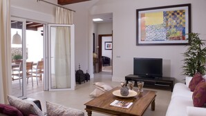 A living room with a TV, a coffee table, and a sofa. - Modern Villa with Heated Pool, Wifi and Air Conditioning in Los Mojones (Puerto del Carmen)