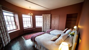 A bedroom with two beds, large windows, a radiator, and a wooden floor. - Unique Historic Apartment sleeping 7 close to St Andrews (Cupar)