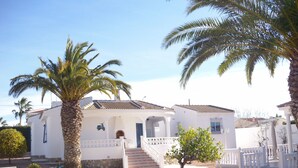 A white building with a tiled roof, a staircase, and a small tree in front. - Beautiful villa with large outdoor kitchen for max. 10 people, swimming pool, air conditioning and wifi (Cdad. Quesada)