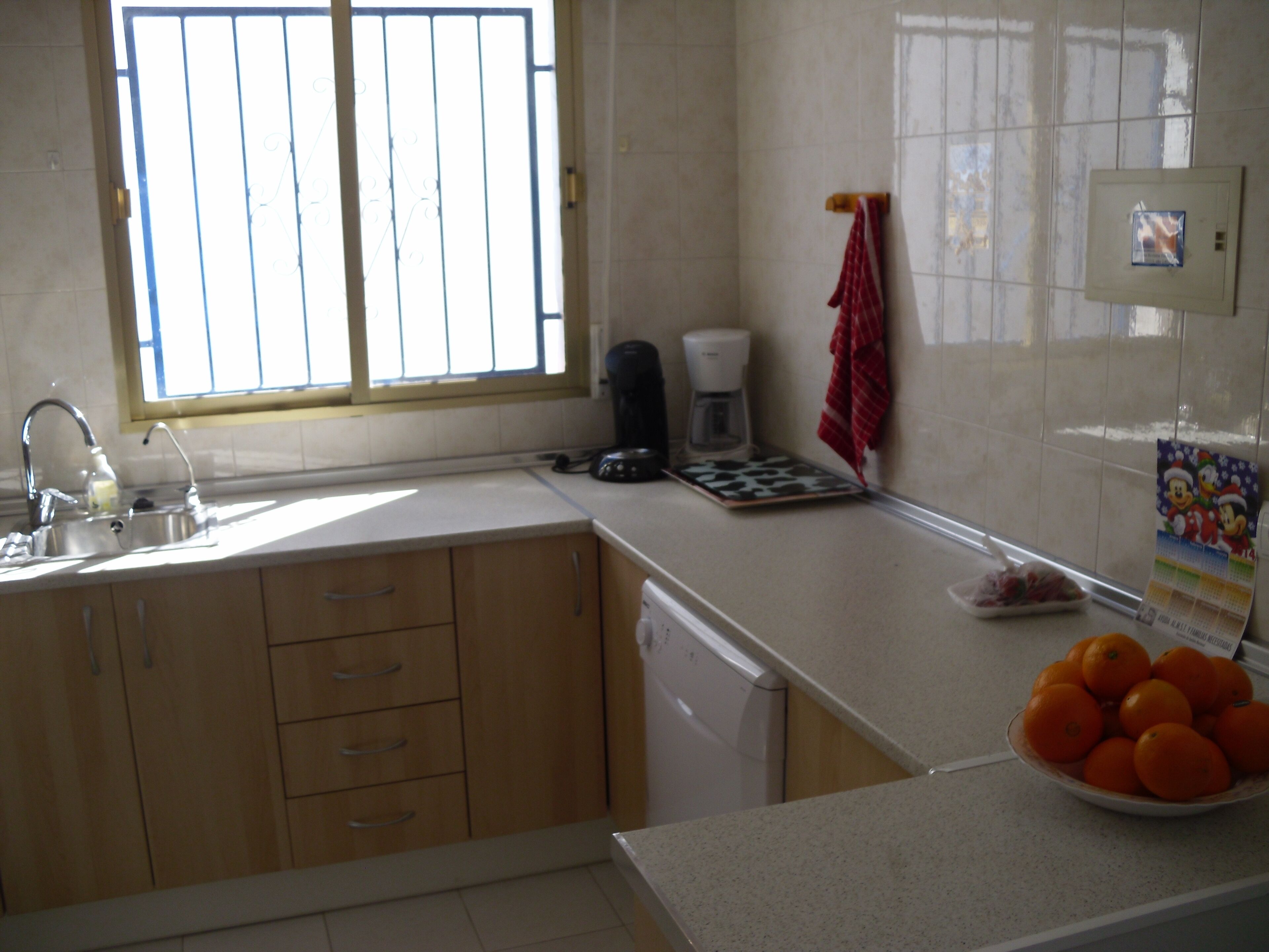 A kitchen with a sink, countertop, and a window.