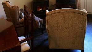 A living room with a fireplace, a television, and a dining area. - Casiopea charming lodging for two persons (Braojos)