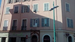 Un edificio rosa con varias ventanas, un letrero que dice 'Flamm & Co' y un cartel de 'Prohibido el acceso'.