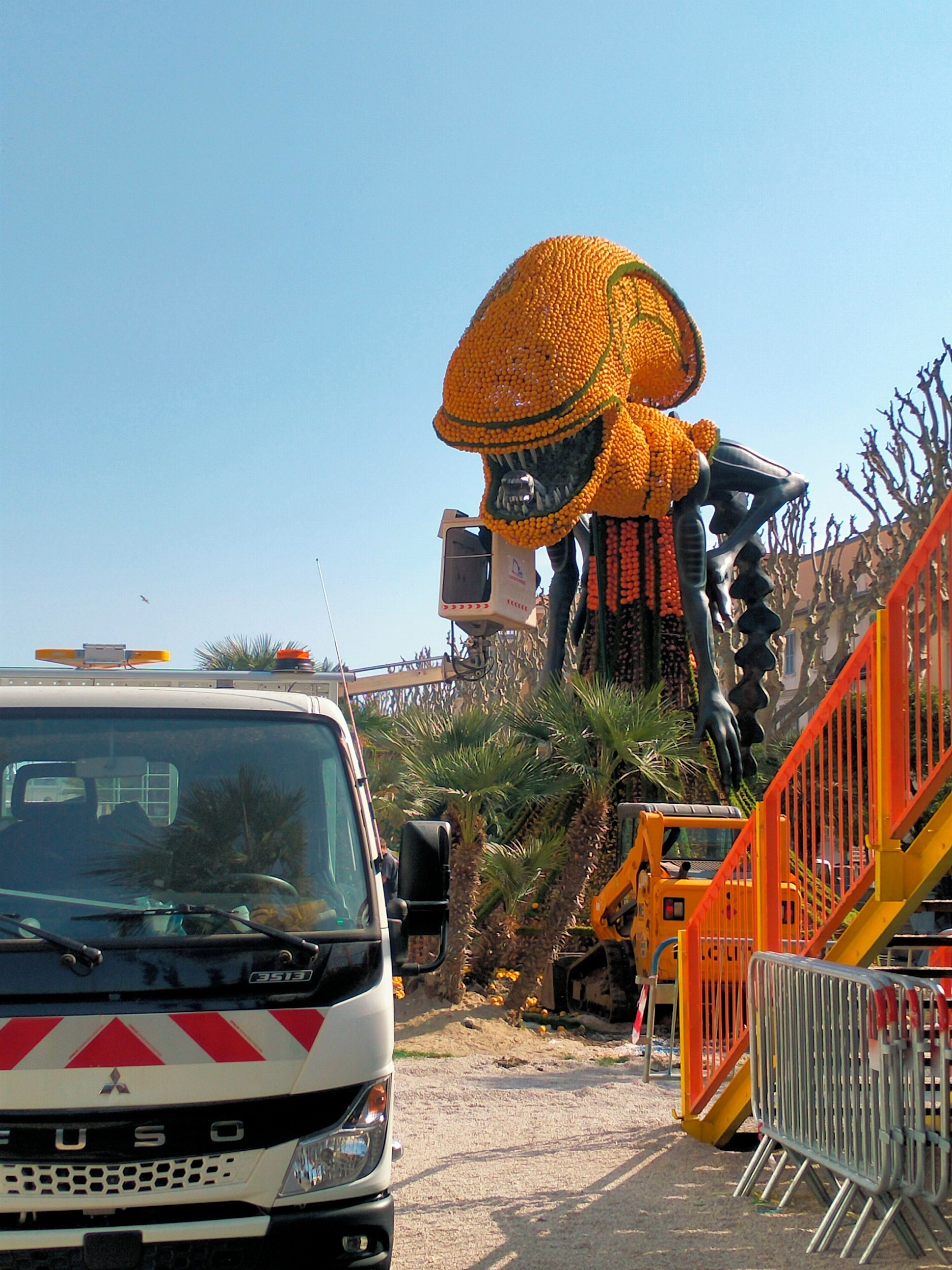 Un vehículo de construcción y una escultura grande y colorida.