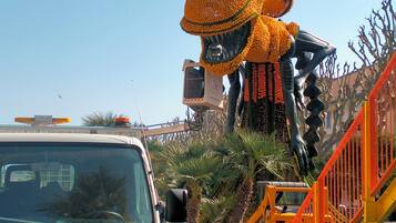 Un vehículo de construcción y una escultura grande y colorida.