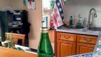 Eine Küche mit Spüle, Schränken und einer grünen Flasche auf der Arbeitsplatte.