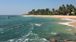 A beach with clear turquoise water, a sandy shore, and palm trees. - Premium Colonial Villa with Pool, charming Staff + Beach House (Ambalangoda)