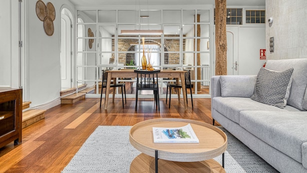 Un salon moderne comprenant un canapé, une table basse et un coin repas avec une table et des chaises.