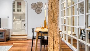Une cuisine moderne avec des meubles blancs, une table à manger en bois et une grande fenêtre offrant une belle vue.
