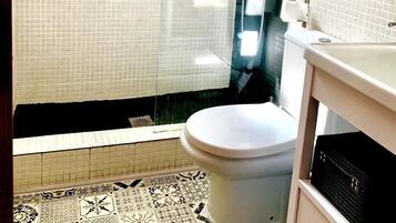 Een douche, handdoeken, zeep, toiletpapier