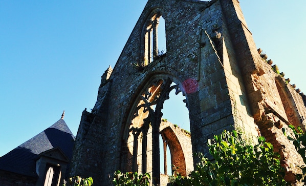 An old stone building with a large arched window and a pointed roof.