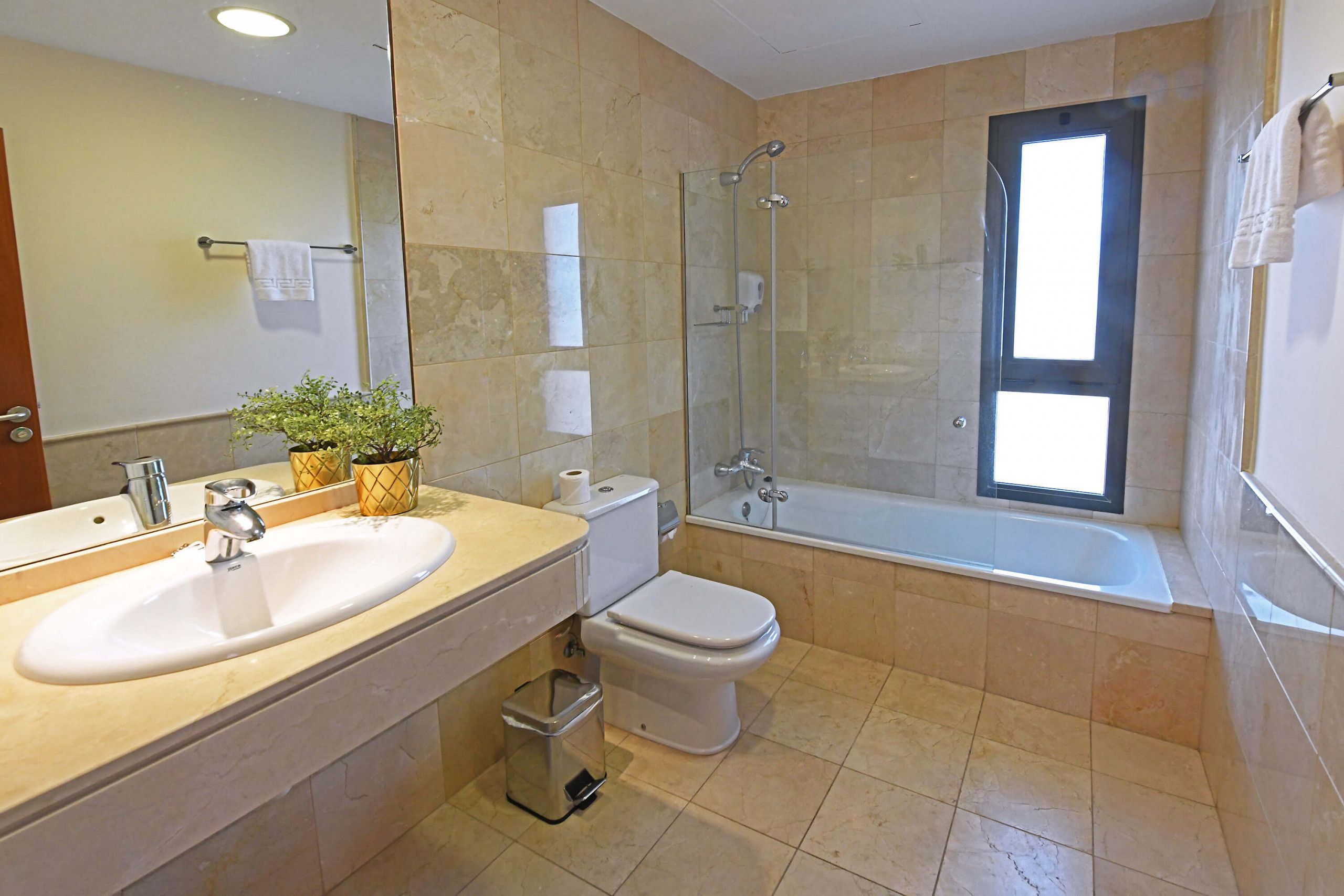 A modern bathroom with a sink, toilet, and glass-enclosed shower.