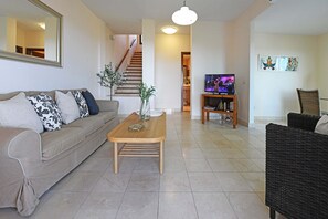 Ein Wohnzimmer mit einer Couch, einem Couchtisch und einem Fernsehschrank.