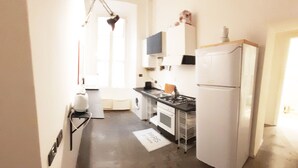 A compact kitchen with a refrigerator, stove, and sink. - Prestigious "farnese loft" (Roma)