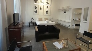 A modern hotel room with a bed, a desk, a sofa, a coffee table, and a TV. - Prestigious "farnese loft" (Roma)