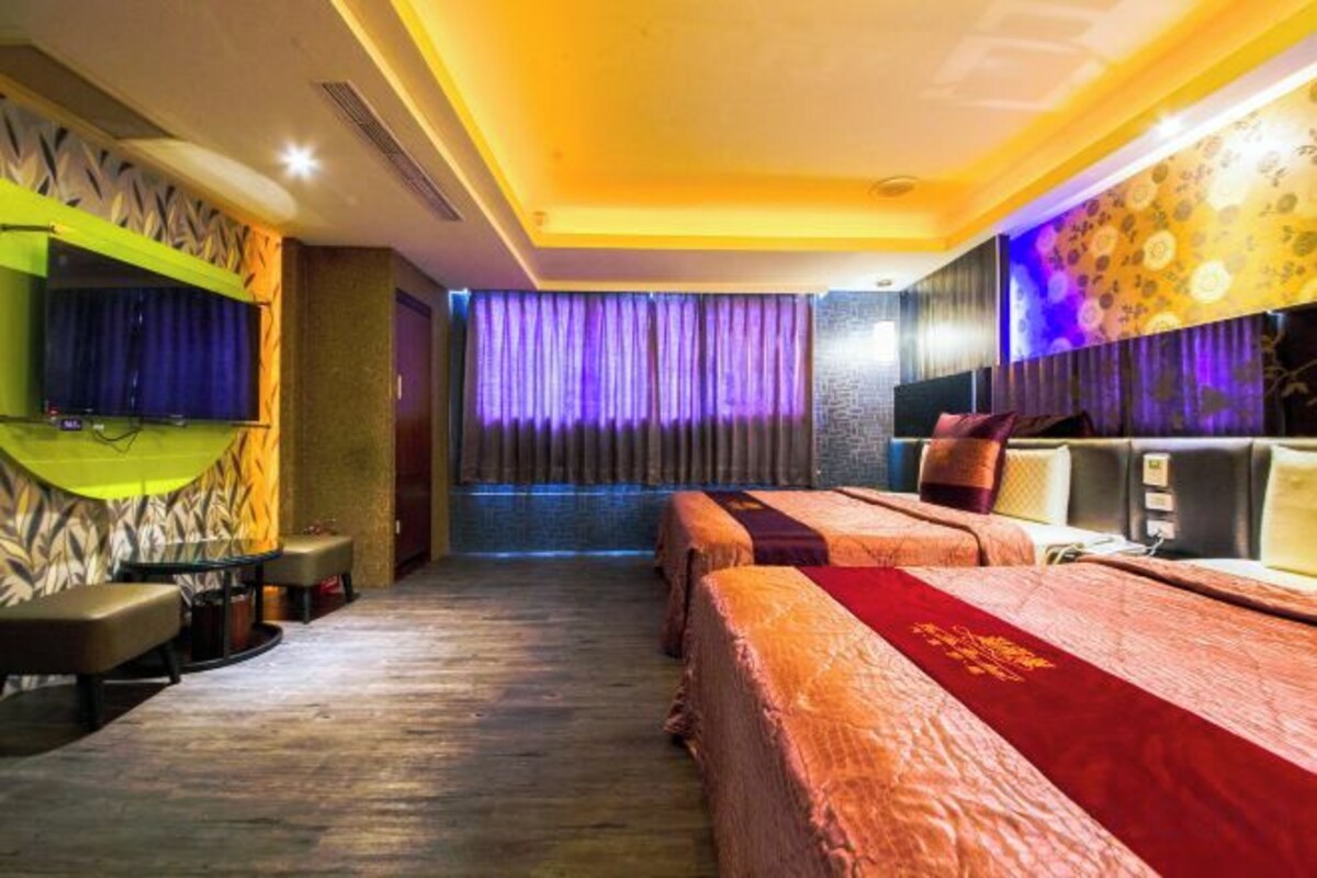 Une chambre d’hôtel avec un grand lit, une télévision et un coin salon.