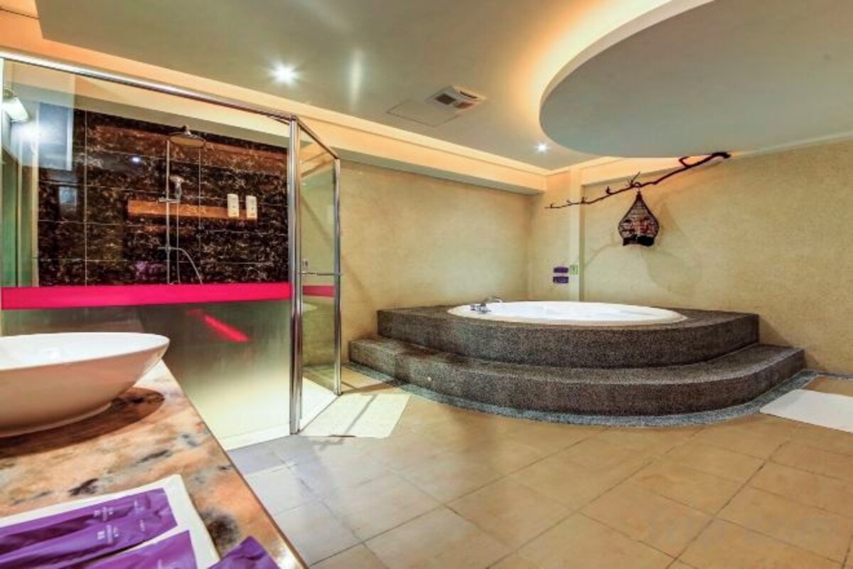 A modern bathroom with a large bathtub, a glass shower enclosure, and a marble countertop.