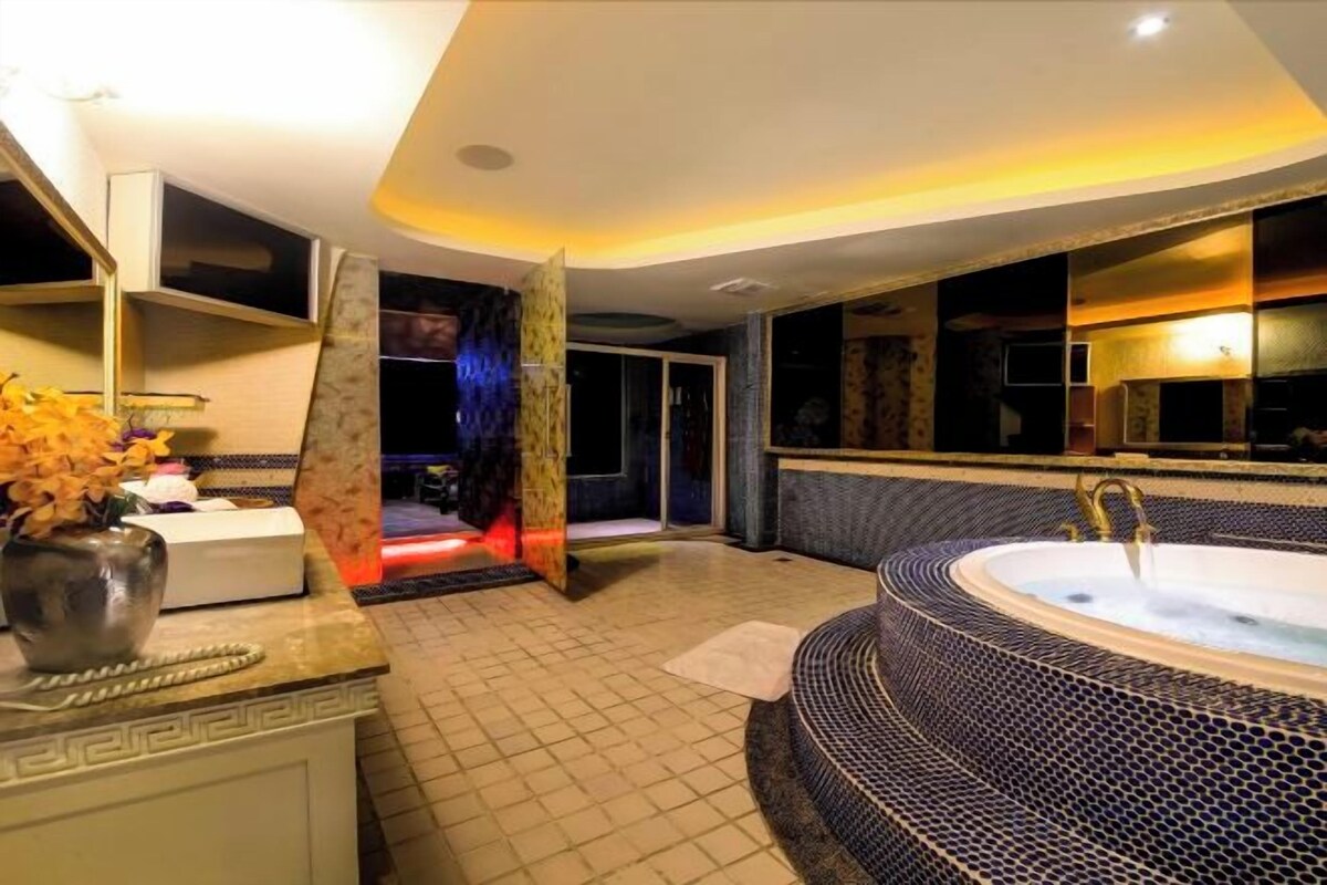 Une salle de bain moderne avec une grande baignoire, un meuble-lavabo avec un miroir et un espace douche.