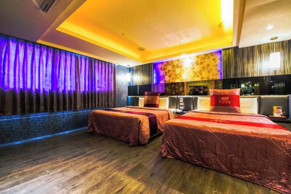 A hotel room with two beds, a massage area, and a reception desk.