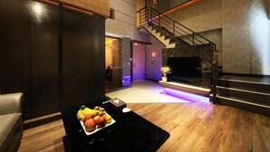 Un vestíbulo moderno con un mostrador de recepción de madera, una escalera y un área de descanso.