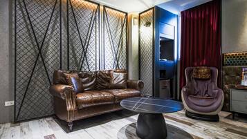 Een moderne woonkamer met een leren bank, een ronde salontafel, een massagestoel en een scheidingswand met een geometrisch patroon.