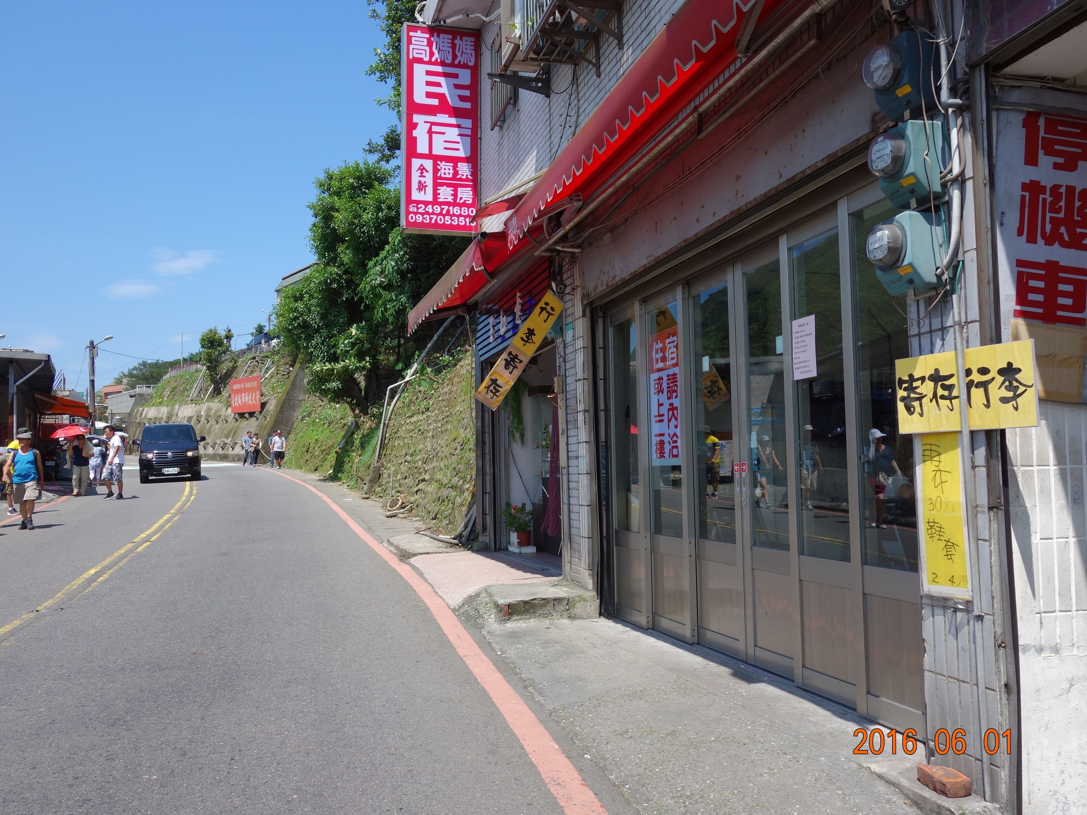 A street view with a building featuring a red awning and multiple signs in a foreign language.