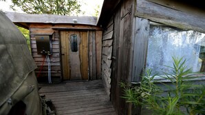 A wooden cabin with a door, a small window, and a wooden staircase leading to a deck. - Yurt [sleeps up to 6] & Bathhouse in E Cornwall UK - 5* Off-Grid  (Callington)