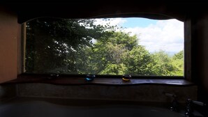 A bathroom with a large window overlooking a lush green landscape. - Yurt [sleeps up to 6] & Bathhouse in E Cornwall UK - 5* Off-Grid  (Callington)