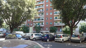 A parking lot with several cars and a multi-story apartment building in the background. - Your Home @ ROME near TRASTEVERE (Roma)