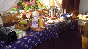 Un bufé de desayuno con diversos alimentos, una cafetera y un tostador.
