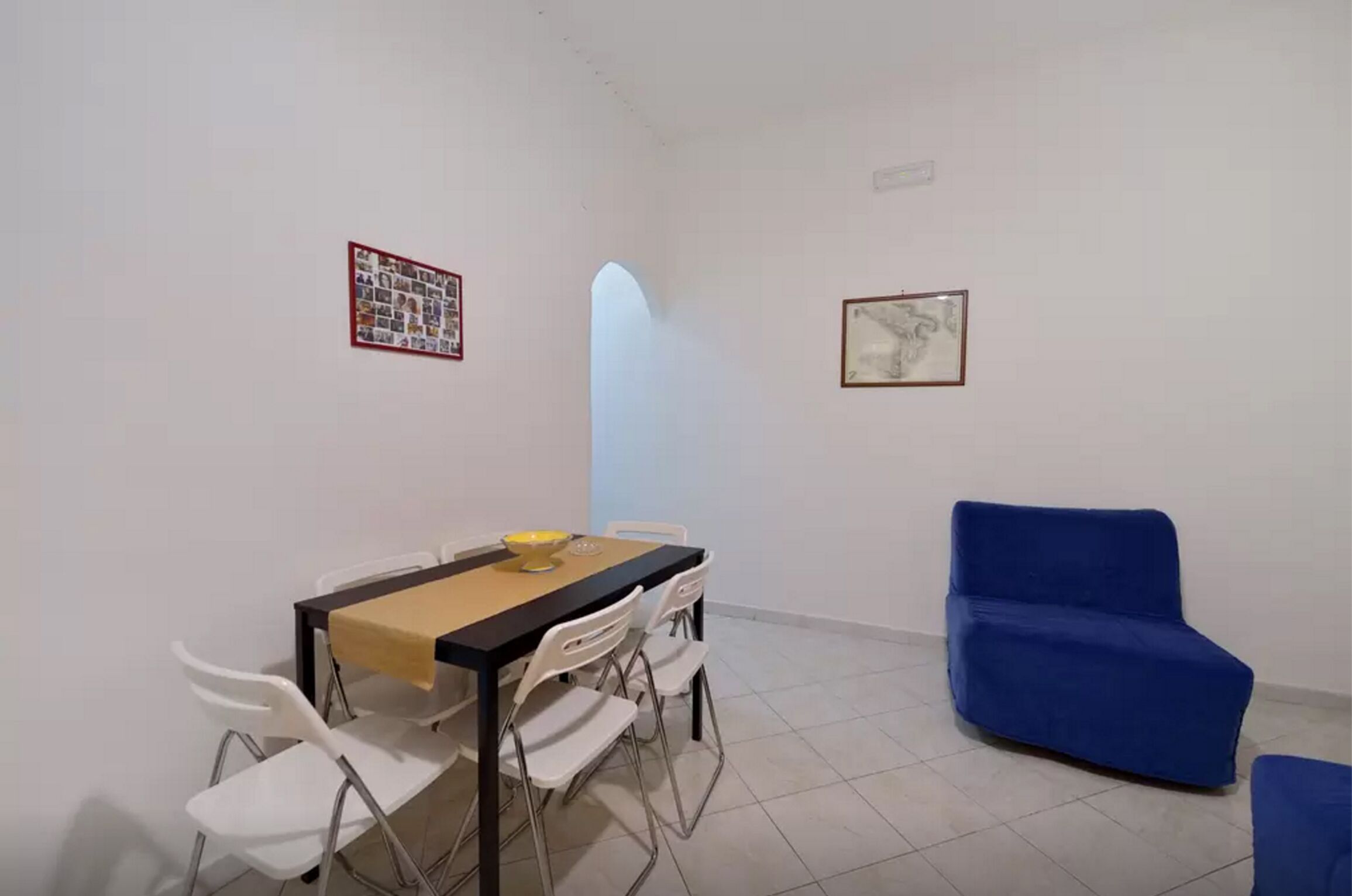 Un coin repas avec une table, des chaises et un canapé bleu.
