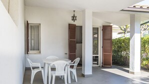 A covered outdoor area with a table and chairs, a door, and a window with shutters. - M051 - Marcelli, villa with garden 200 meters from the sea (Marcelli)