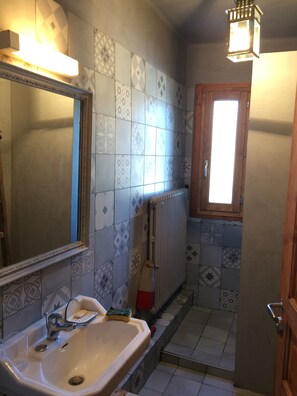 A bathroom with a sink, mirror, patterned tiles, and a window. - Large apartment in mountain house in Risoul - 05600 (Risoul)