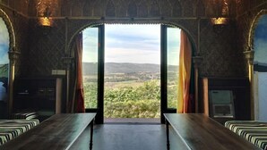 Quarto com uma grande porta arqueada que dá para uma vista panorâmica.