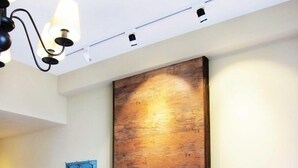 A room with a built-in fireplace, a wall-mounted TV, and a hanging coat rack. - Wefun Inn (Jinning)