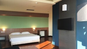A hotel room with a bed, bedside tables, a TV, and a wooden floor. - Wefun Inn (Jinning)