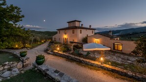 A large, single-story house with a stone pathway leading to the entrance, surrounded by greenery and a stone wall. - Villa just 14 km to Florence, 8 bedrooms. Garden, private pool and Wi-Fi! (Rignano sull'Arno)