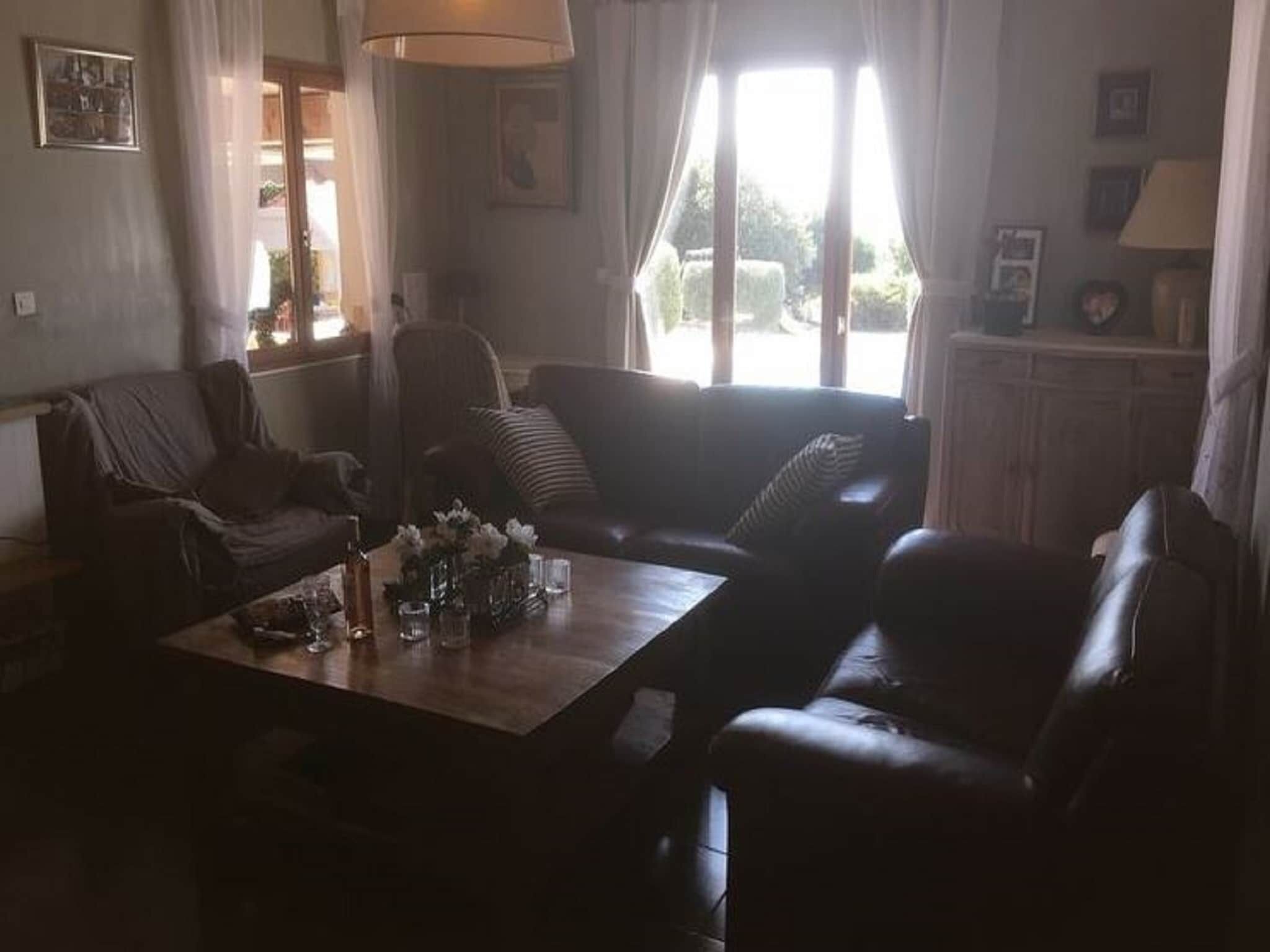 Ein Wohnzimmer mit einer Couch, Sesseln, einem Couchtisch und einer Lampe.