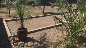 A garden with neatly trimmed hedges and a paved area. - Villa Retreat with Pool and pets (Vélieux)