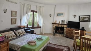 A bedroom with a bed, a television, a fireplace, and a window with curtains. - Beautiful Villa in El Campello with Private Pool and a Step from the Sea (El Campello)