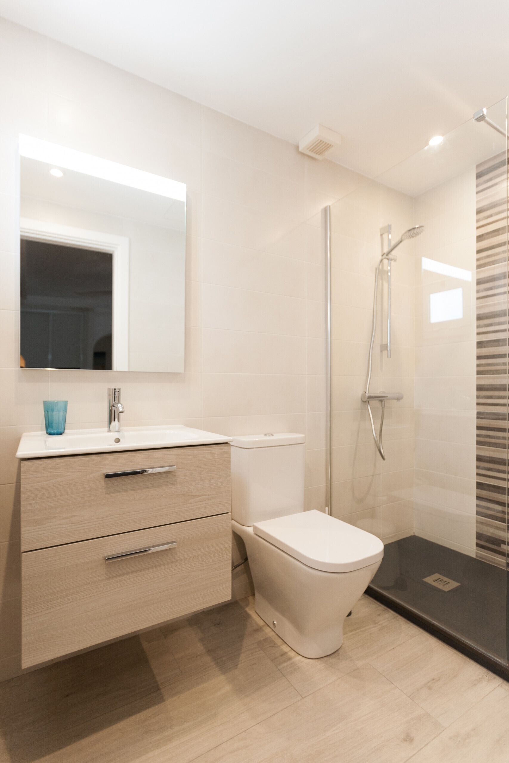 Ein modernes Badezimmer mit Waschbecken, Spiegel und Toilette.