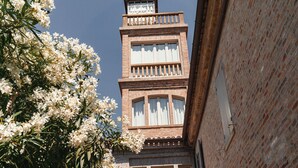 A multi-story building with a brick facade and large windows. - On the ground floor of an old farmhouse, in the countryside with a swimming pool (Pesaro)