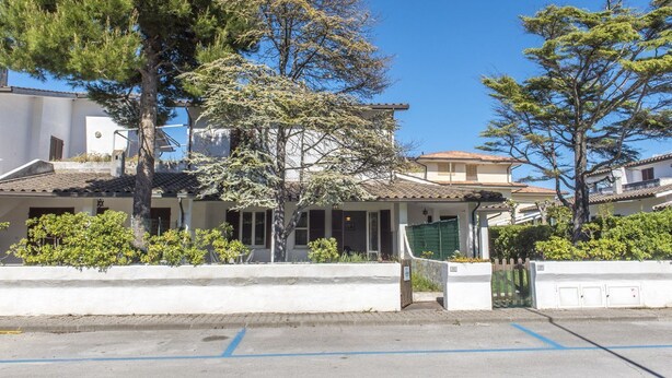 A residential building with a tiled roof, a gated entrance, and a clear blue sky. - M050 - Marcelli, three-room apartment with garden 200 meters from the sea (Marcelli)