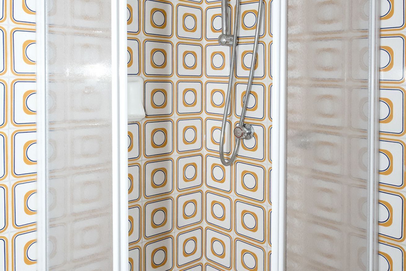 Et brusebad med et geometrisk flisemønster.